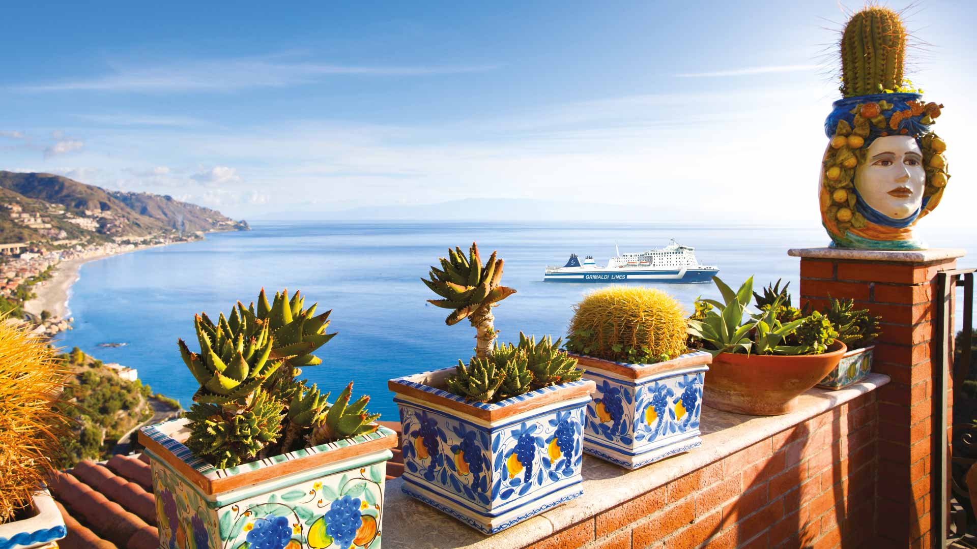 panorama del mare siciliano con cactus e nave grimaldi