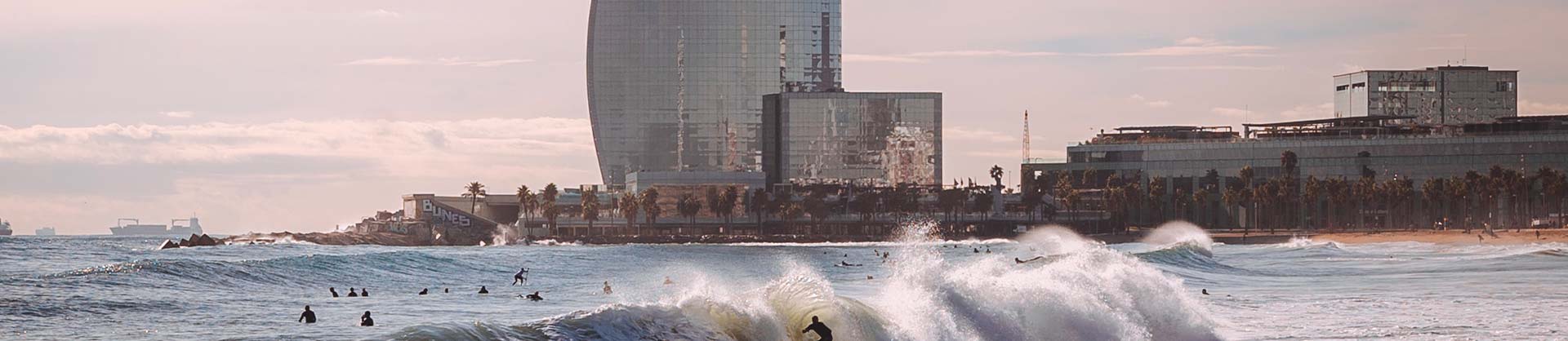 spiaggia di barcellona con onde e surfisti