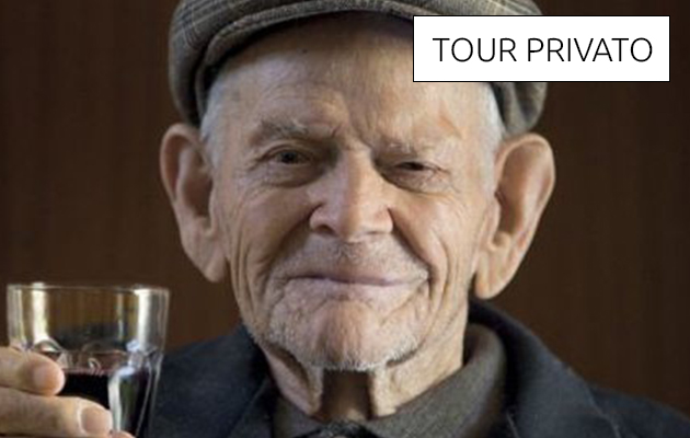 Foto di un anziano sardo con un bicchiere di vino in mano