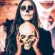 festa di halloween in spagna ragazza mascherata con teschio in mano