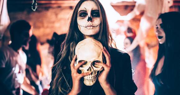 festa di halloween in spagna ragazza mascherata con teschio in mano
