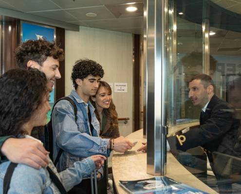 Ragazzi che presentano i documenti di viaggio al banco reception Grimaldi Lines